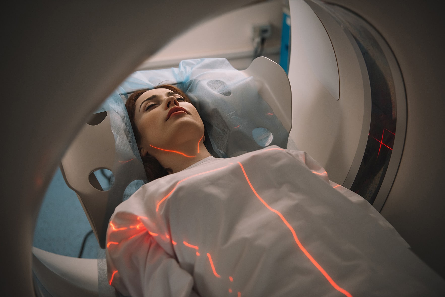 A woman laying underneath a ct scanner